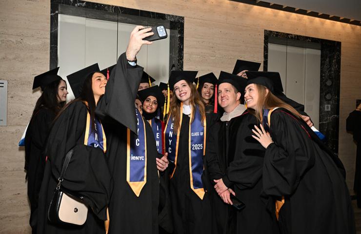 A group of graduates taking a selfie together at their graduation ceremony.