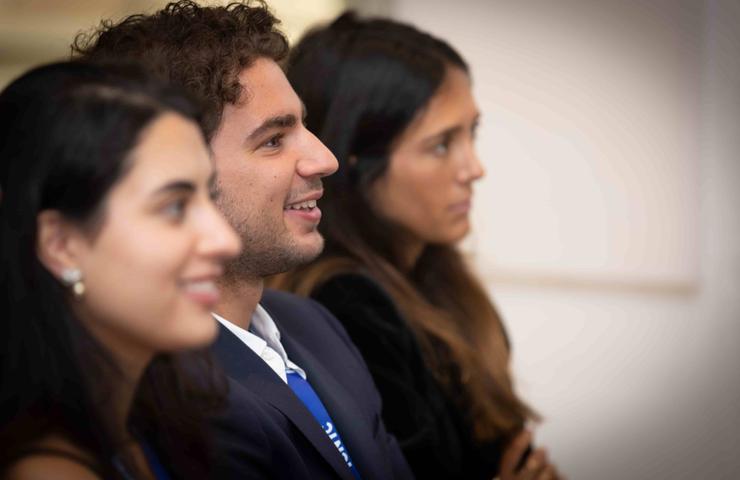 Three people engaged in conversation or listening attentively.