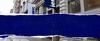 A street view showcasing a building with a blue sign.