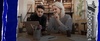 Two young adults are collaborating on a laptop at a table filled with stationery in a modern workspace.