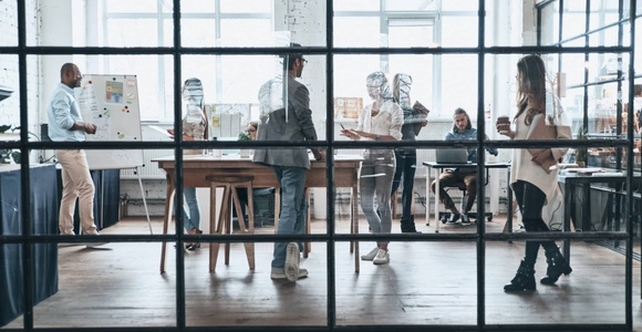 A bustling modern office space with multiple workers engaged in various activities.