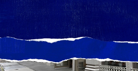 The image features a bold blue torn paper design juxtaposed with a city street view.